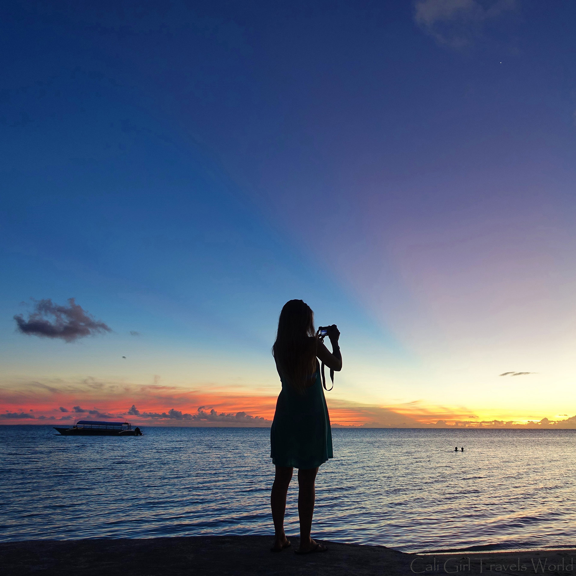 Cali Girl Travels World taking a photo on the main beach Matira on Bora Bora at Sunest.